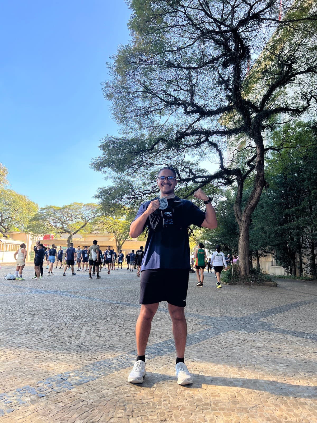 João Guedes mostrando a medalha ao completar sua primeira meia maratona